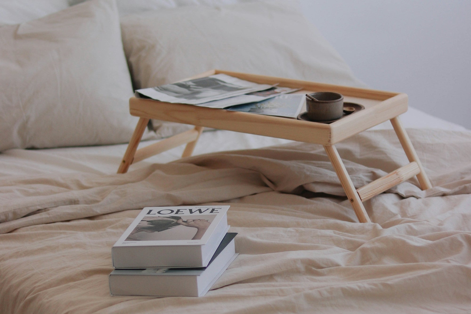 Bed with a breakfast tray and books