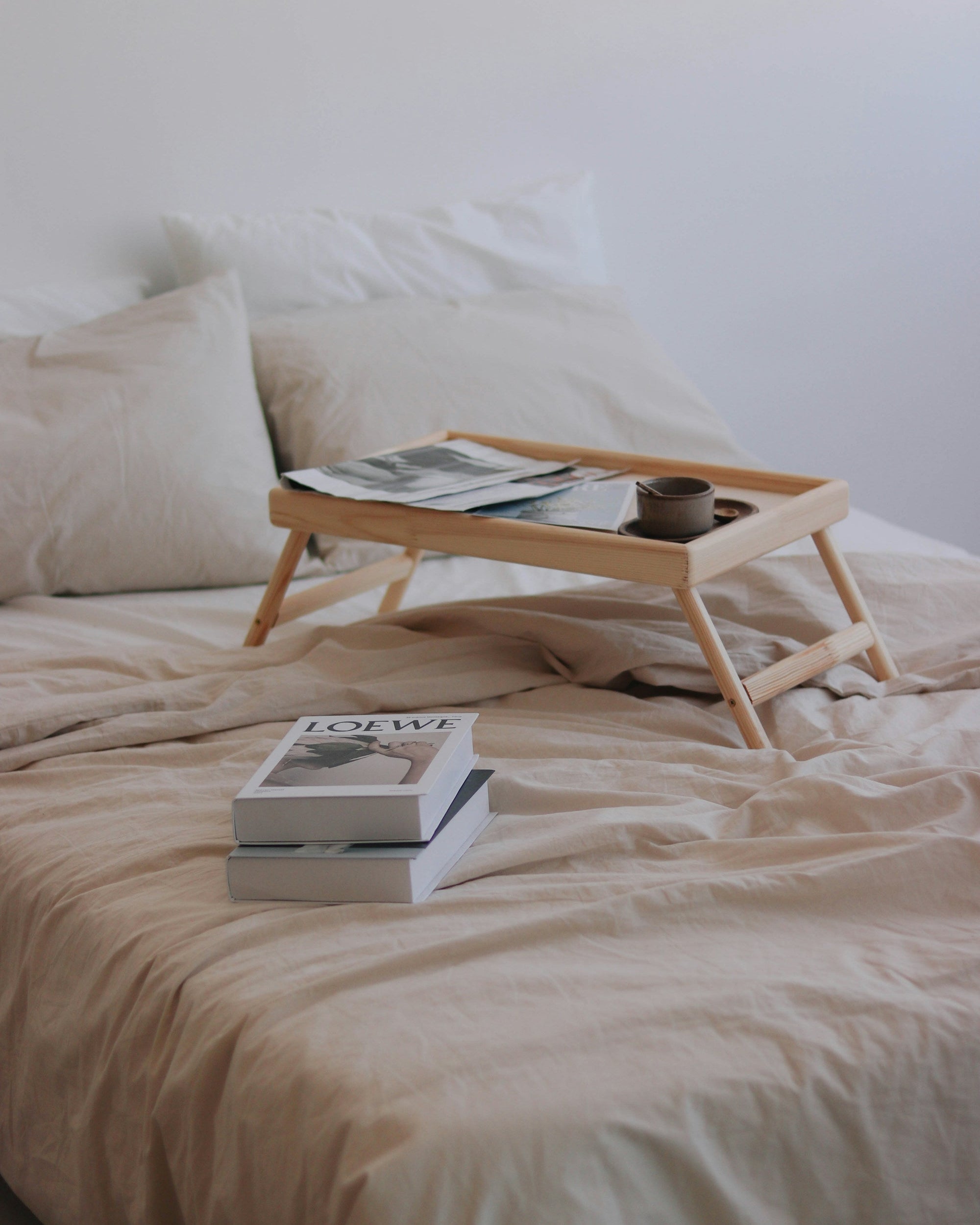 Bed with a breakfast tray and books