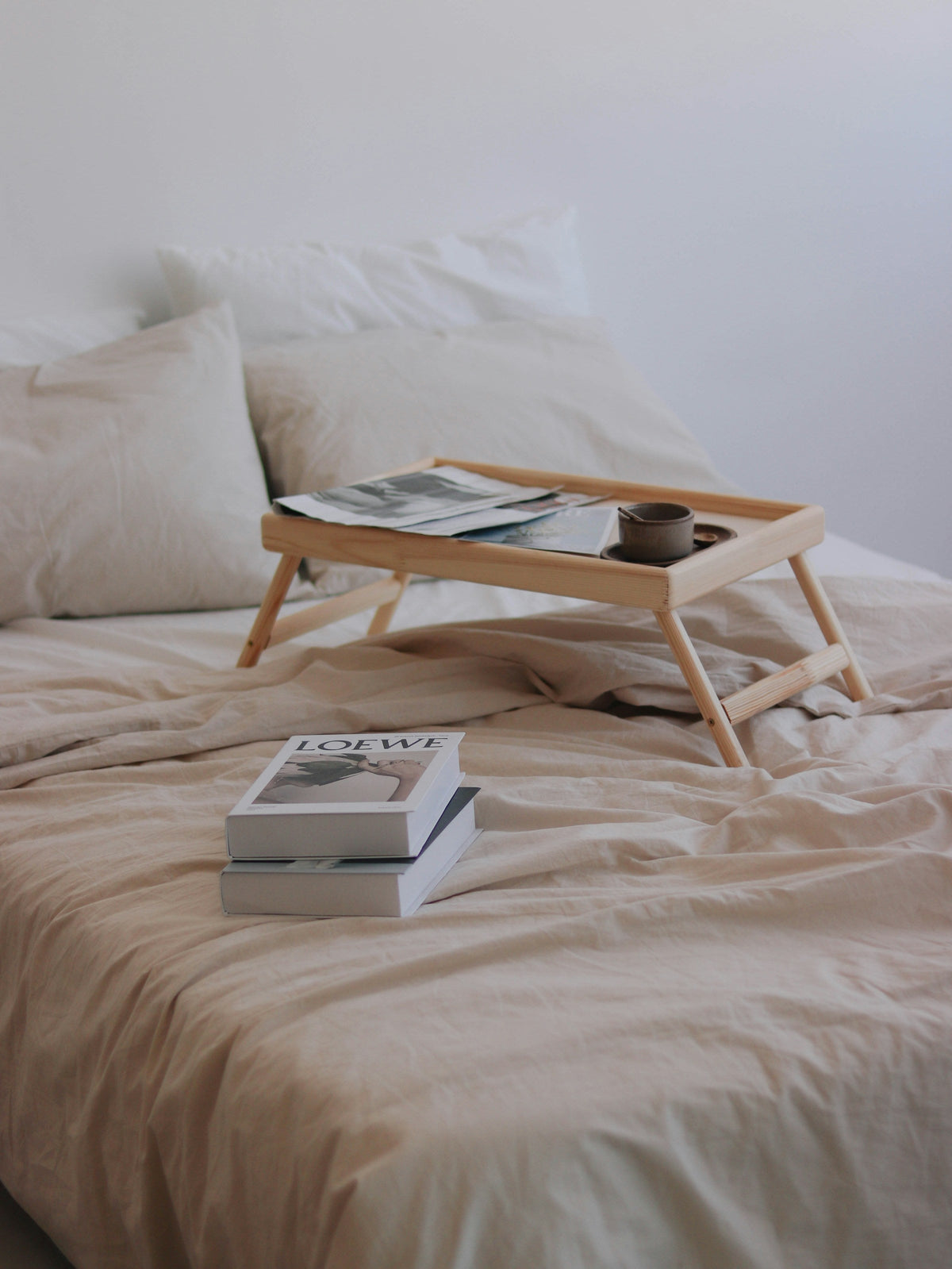 Bed with a breakfast tray and books
