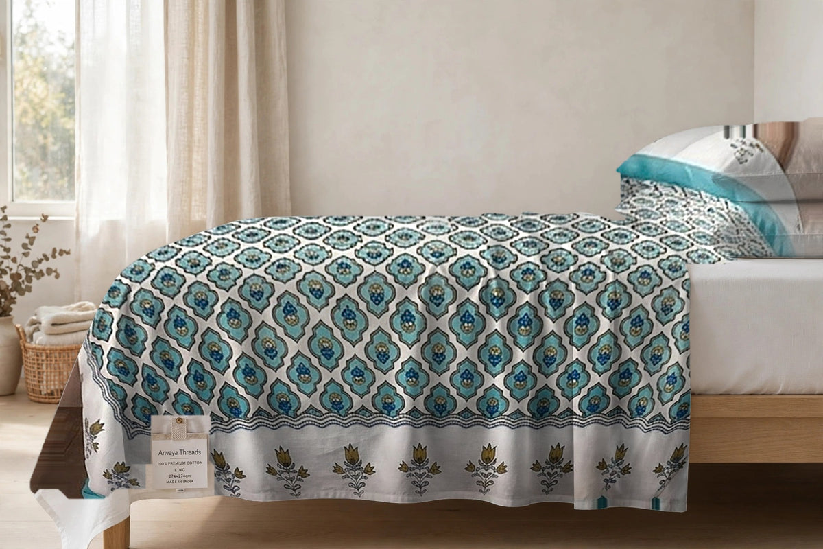 Pankh Jaal Firoza bedsheet seen from the side, falling over the edge of the bed