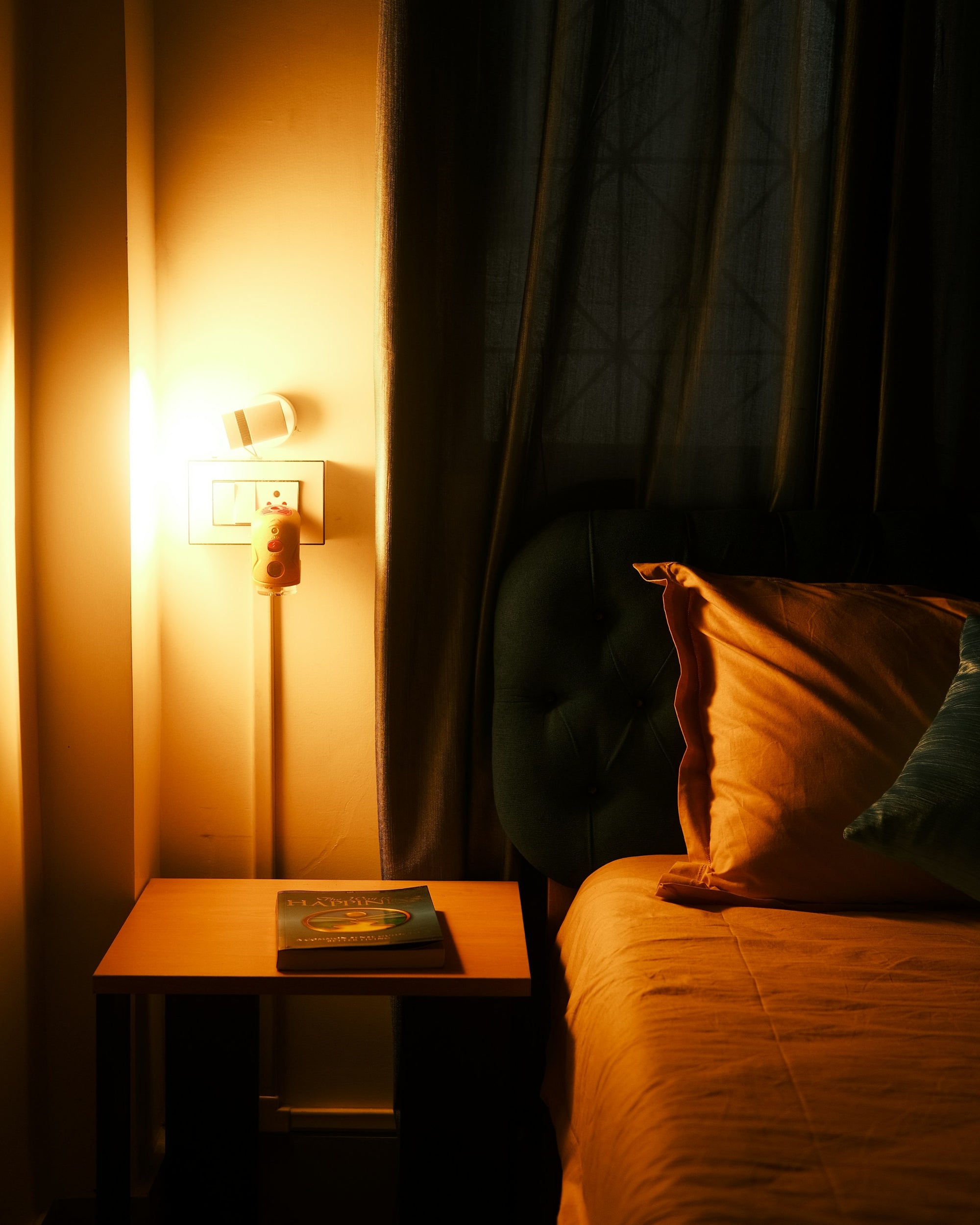 Bed in warm bedside lamp light at night