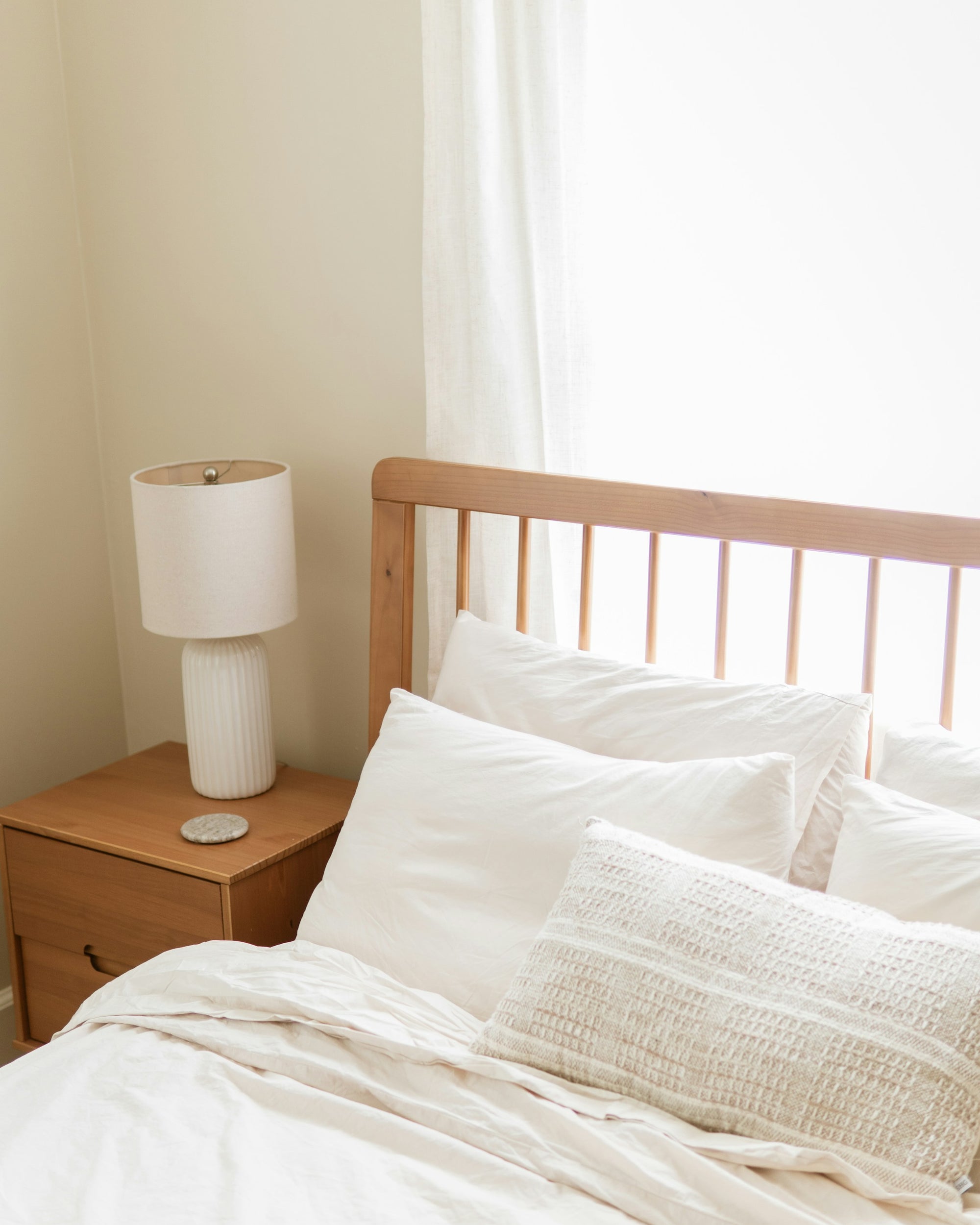 White cotton bedding on a wooden bed in daylight
